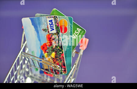 Yaroslavl, Russia - August 20, 2019: Mini shopping trolley with credit cards on the table. Stock Photo