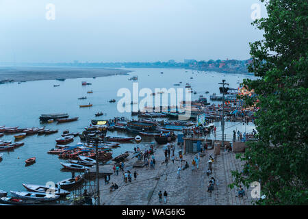 Boats with tourists on water of Ganges River close to Ghat at dusk Stock Photo