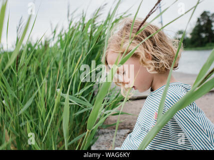 portrait of a young girl sat in the grass at the beach on vacation