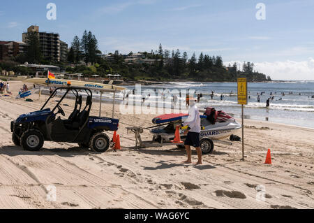 A life guard patrols the beach, driving a Quadbike towing a jet-ski whilst on duty at Kings beach in Caloundra on the Sunshine Coast in Queensland, Au Stock Photo