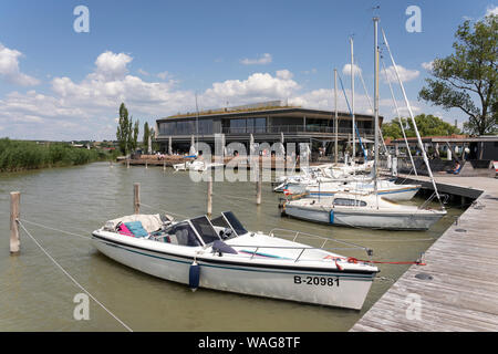 Boats moored along a jetty outside das Fritz, a popular bar and restaurant in Weiden am See in Burgenland, Austria Stock Photo