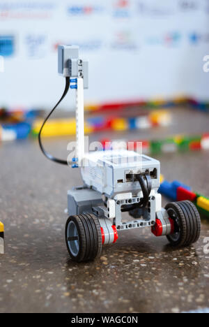 Perm, Russia - February 19, 2019: small real programmable robot on wheels moves through an artificial labyrinth, soft focus Stock Photo