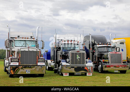 Alaharma, Finland. August 9, 2019. Classic American Kenworth W900B and two Peterbilt big rigs with shiny chrome lined up on Power Truck Show 2019. Stock Photo