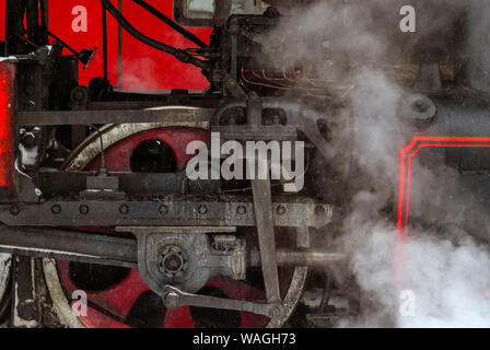 closeup of a steam locomotive wheel with valve gear and connecting rods Stock Photo