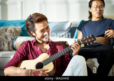 asian young adult men relaxing and enjoying music and beer at party Stock Photo