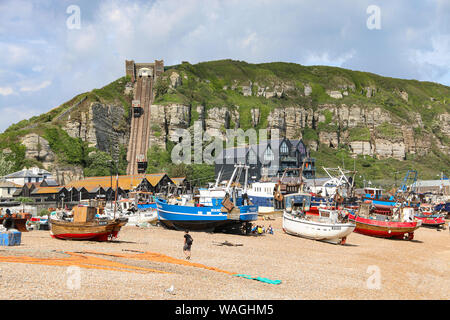 Fishing boats with paraphenalia on the shingle beach of the Old Town, with the steep funicular railway int he background, Hastings, East Sussex, UK Stock Photo