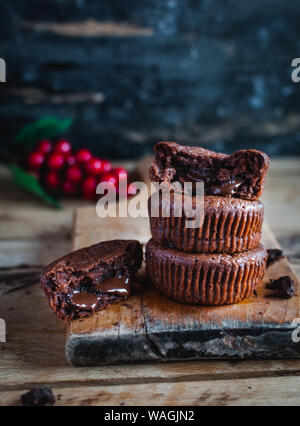 Close-up of homemade chocolate muffins on rustic cutting board Stock Photo
