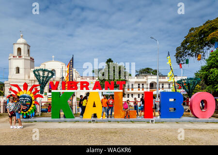 Visitors Pose In Front Of A Vibrant Kalibo Sign During The Ati-Atihan Festival, Kalibo, Panay Island, Aklan Province, Western Visayas, The Philippines Stock Photo