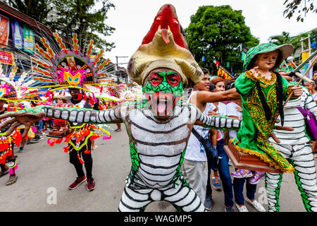 People In Colourful Costumes Holding Santo Nino Statues Parade Through The Streets Of Kalibo During The Ati-Atihan Festival, Kalibo, The Philippines. Stock Photo