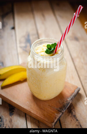 Mango smoothie in a jar on wooden table Stock Photo