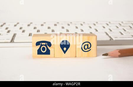 Contact icons on wooden blocks with keyboard, Contact Us concept Stock Photo