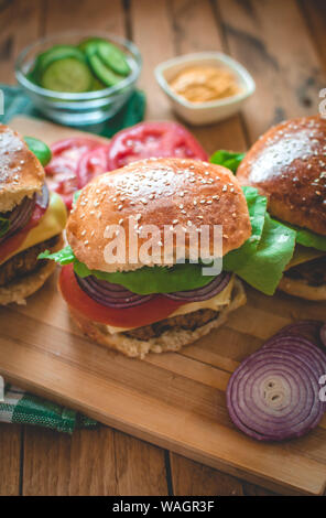 Close-up of homemade burgers on cutting board Stock Photo