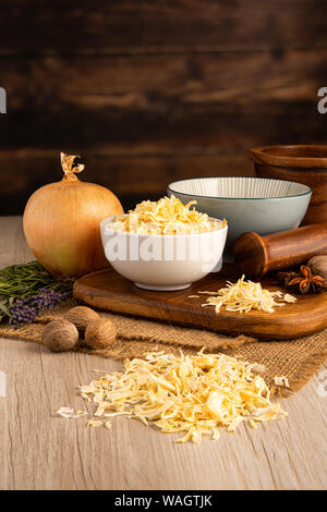 Dry Kibbled Onions in a bowl and food preparation and kitchen setting Stock Photo