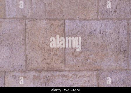 beige weathered granite stone tiled wall background. texture. Stock Photo