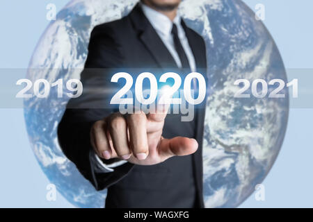 Businessmen are touching the year 2020 and are in transition of the times in the business world. Concept of targeting for success. The Earth element Stock Photo