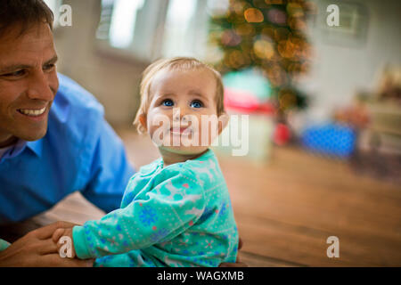 Happy father spending time with his baby daughter at Christmas. Stock Photo