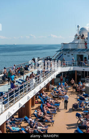 Passengers sunbathing on the Pool Deck of a Cruise ship Stock Photo