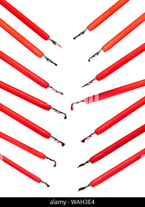set of red dip pen holders with ink drops cut out on white background Stock Photo