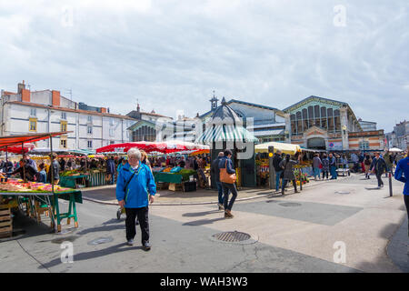 La Rochelle, France - May 08, 2019: Market square with stalls, shopping arcade, sellers and shoppers in La Rochelle, France Stock Photo