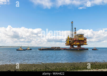 After over 40 years of oil production, the decommissioned Brent Bravo oil rig is towed into the River Tees estuary to be broken up for scrap. Stock Photo