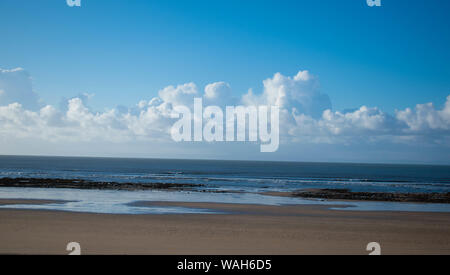 White billowing clouds against a blue sky over Swansea Beach, Wales, U.K. Stock Photo