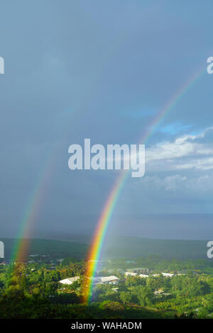 Rainbows over industrial buildings in Captain Cook, Hawaii Stock Photo