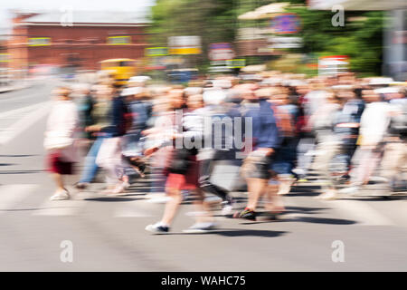 Blured crowd of people walking on the busy city street. Motion blured people. Slow shutter speed. People silhouette on the street. Stock Photo