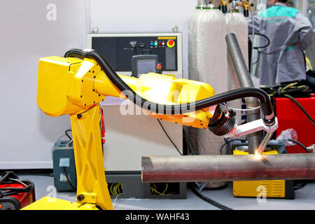 Yellow robotic arm for automatic welding pipes Stock Photo