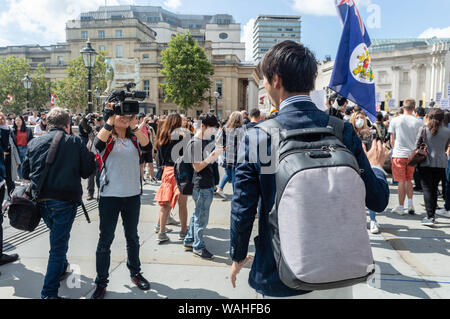 London, United Kingdom - August 17,  2019:  Japanese news correspondent reporting the UK Solidarity with Hong Kong rally. Stock Photo
