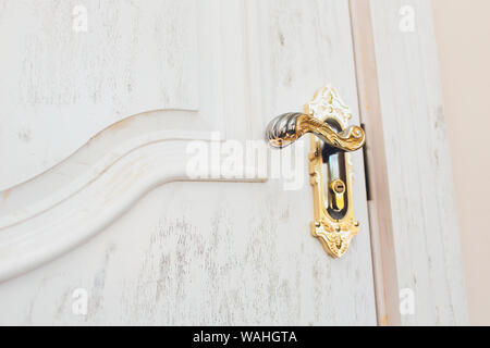 Close up of classic golden door handle on white door Stock Photo