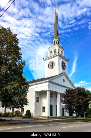 New England white wooden church with steeple and clock. The First Parish Church is a historic landmark located in the Billerica Town Common District.