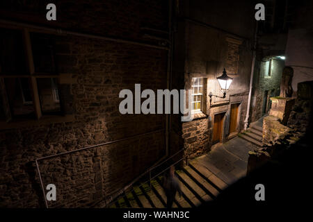 Advocate's Close looks spooky at night with lamp posts illuminating the dark passage leading from the Royal Mile in Old Town, Edinburgh Stock Photo