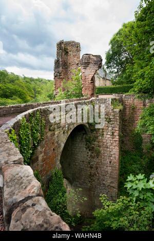 A tall brick and stone arched bridge leads to the ruins of Roslin (Rosslyn) Castle beyond the visible fragments of the Gatehouse, meters from the famo Stock Photo