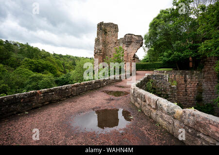 A tall brick and stone arched bridge leads to the ruins of Roslin (Rosslyn) Castle beyond the visible fragments of the Gatehouse, meters from the famo Stock Photo
