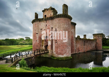 Front view of triangular Caerlaverock Castle surrounded by water moat on a cloudy day, Scotland, Dumfries, UK Stock Photo