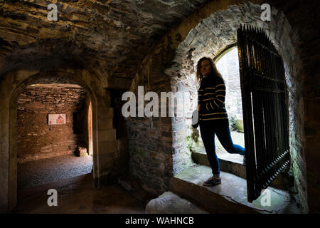 Teenage girl steps into the Priory catacombs where ancient Celtic crosses were found in the Birthplace of Christianity dating from 4th century, Whitho Stock Photo