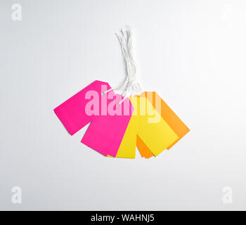 rectangular paper pinks, yellow and orange tags for things on a white rope, white background Stock Photo
