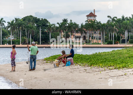 Hispanic family fishing from an island in the Lake Worth Lagoon across from President Donald Trump's Palm Beach mansion estate, Mar-a-Lago. (USA) Stock Photo