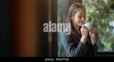 Beautiful businesswoman enjoying coffee during the coffee break in the office Stock Photo