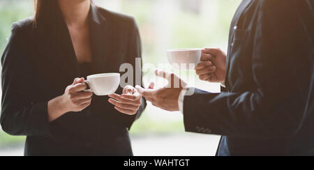 Professional business team discussing while having coffee break during the meeting Stock Photo