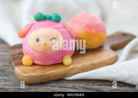 Cute Chinese Pastry or moon cake stuffed with salted egg yolk on wood plate Stock Photo