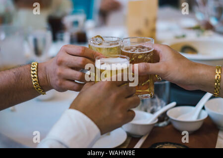 Hands holding beer glasses for celebration in the party Stock Photo