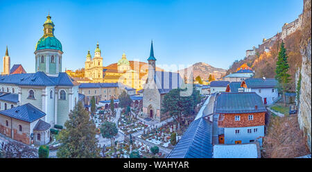 The panoramic view from the catacombs in the rock of the courtyard of St Peter cemetery with  its chapels and huge Cathedral on the background, Salzbu Stock Photo