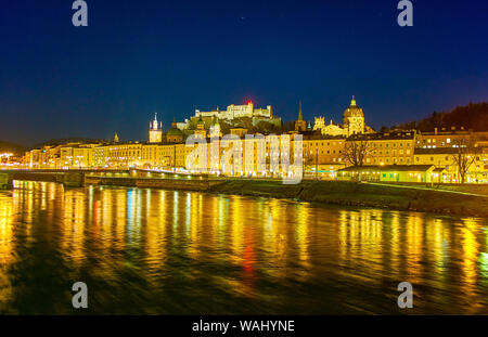 The night view on old Salzburg with medieval edifices in Altstadt district and fast flowing Salzach river, Austria Stock Photo