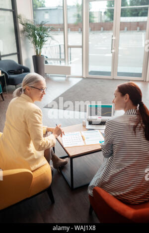 Two businesswomen sitting in front of a laptop