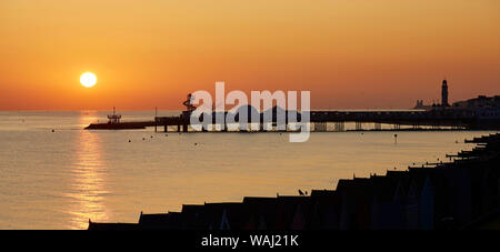 Herne Bay, Kent, UK. 21st August 2019: UK weather. A glorious clear sunrise over Herne Bay pier, with the towns historic clock tower on the right, one of the earliest free standing clock towers built in the UK, and Reculver towers on the horizon. Forecasts of high twenties and even early thirties are being made for the bank holiday weekend. Credit: Alan Payton/Alamy Live News Stock Photo