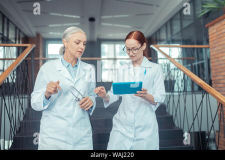 Female doctors in white coats on the stairs Stock Photo