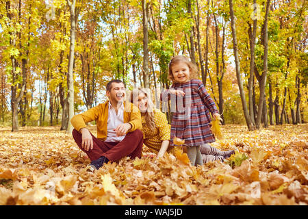 Happy family playing in the park in the fall. Stock Photo