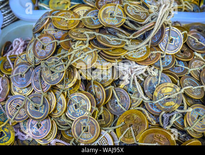 Old Chinese Copper Qing Dynasty Money Coins, Panjuan Flea Market, Beijing, China. Panjuan Flea Curio market has many fakes, replicas and copies of Chinese products. Chinese would tie money together to hide it before there were banks. Stock Photo