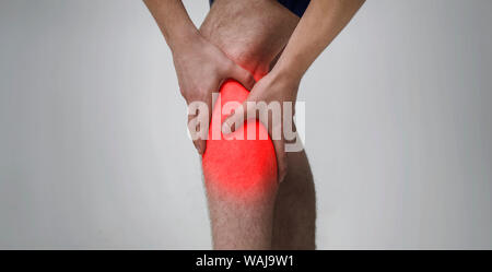 Man massaging his inflamed knee, close up Stock Photo